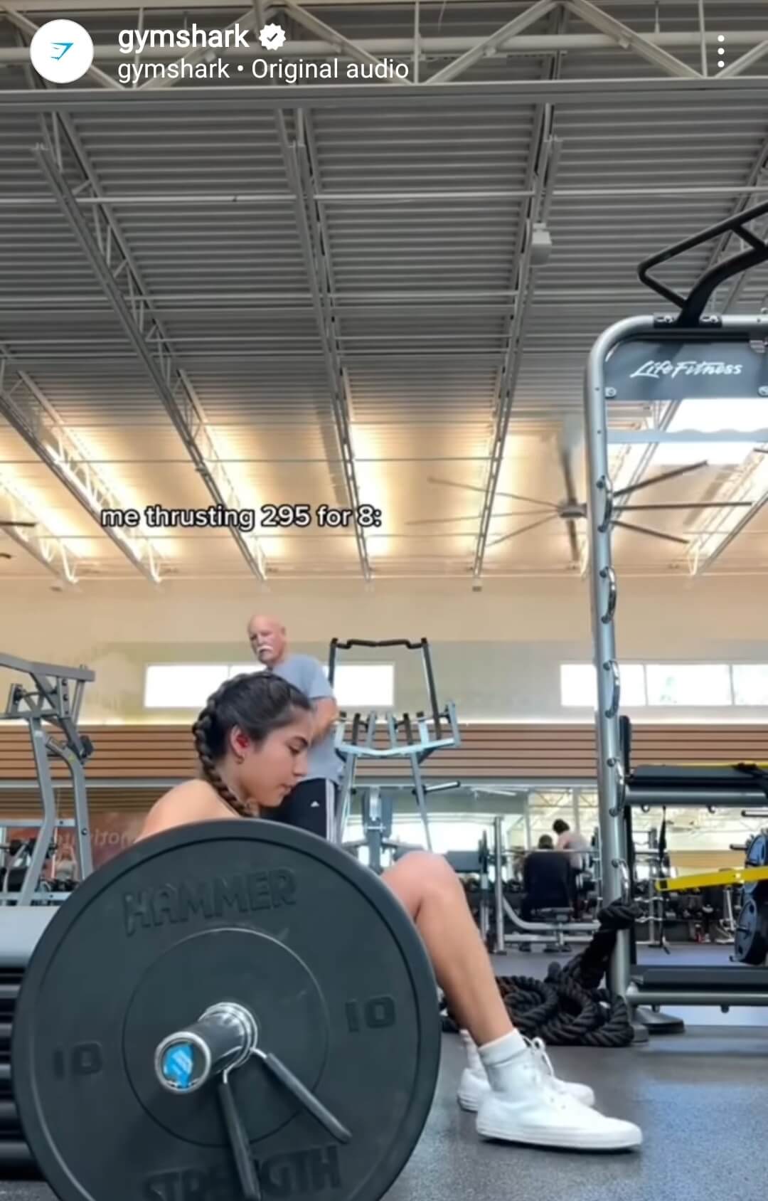 Girl pushing large weights in gym shown on Gymshark social channel.