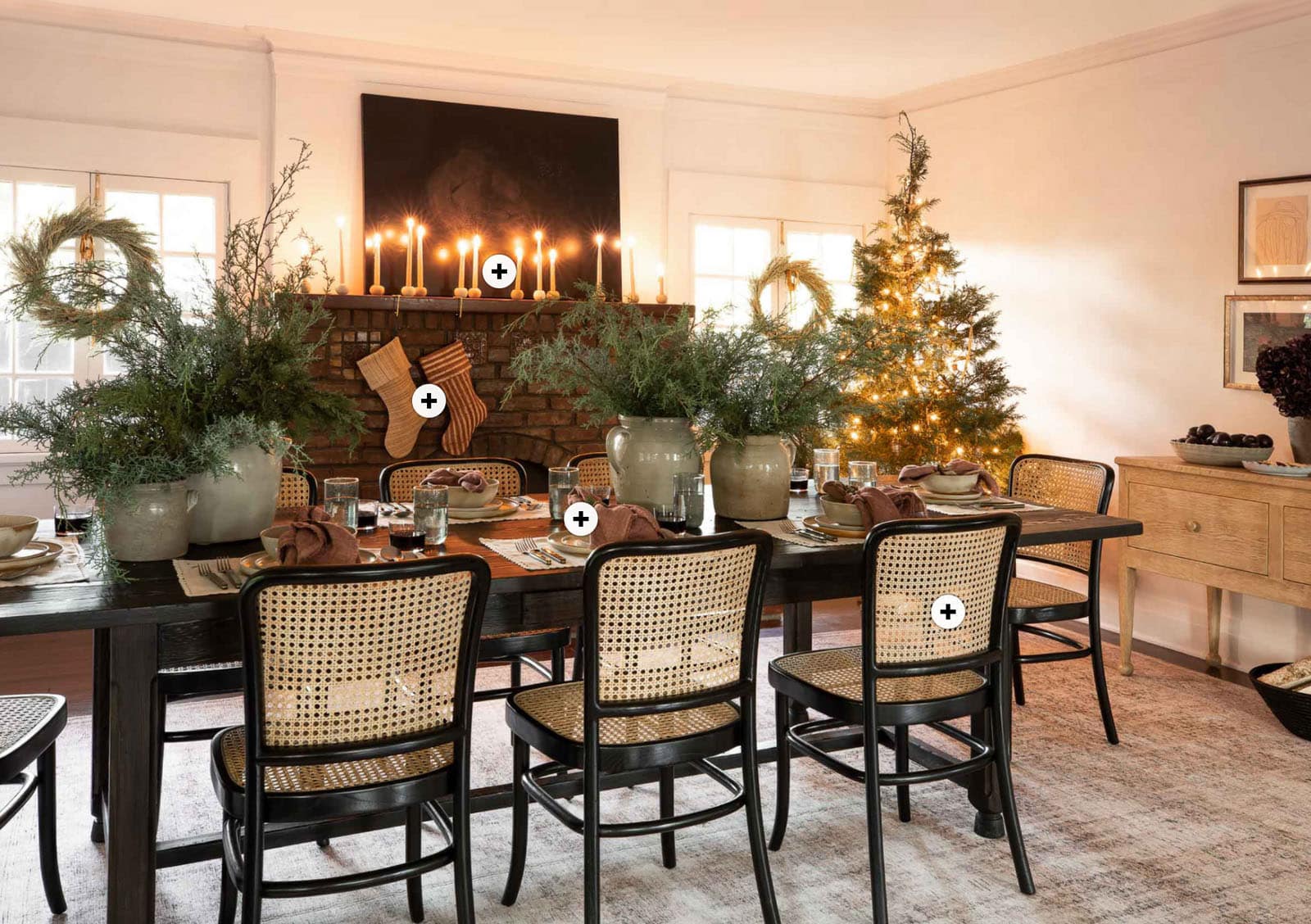 Cozy living room with many Christmas decorations such as candles, socks, and a Christmas tree.